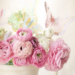 Ranunculus asiaticus in white urn with silk butterflies