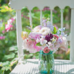 Ranunculus and roses in vintage jar